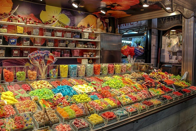 A colorful candy store counter with dozens of bins full of all different kinds of candy.